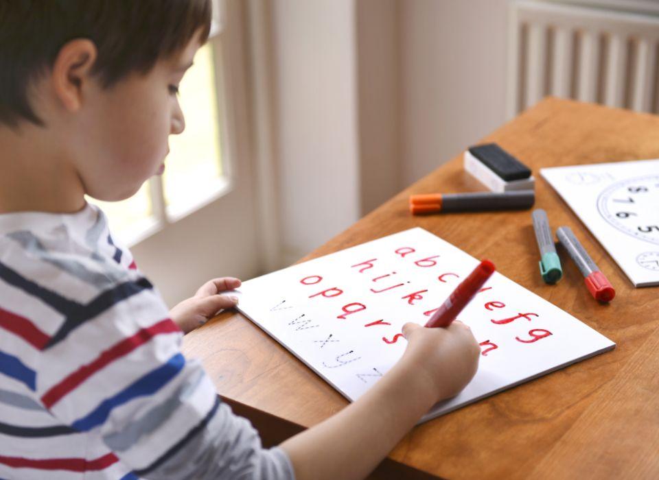 Chłopiec zapisujący litery i cyfry